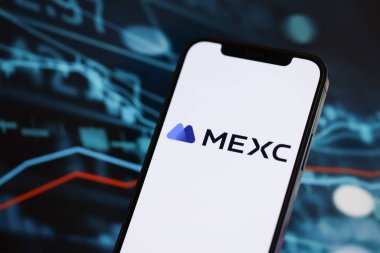 KYIV, UKRAINE - iPhone ekranında 15 Mart 2024 MEXC logosu ve kripto para birimi değer grafikleri. Kripto döviz portalı