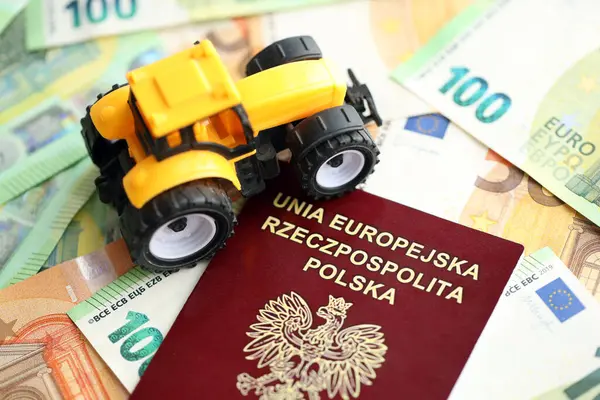 폴란드어 여권과 청구서에 노란색 트랙터 클로즈업 — 스톡 사진