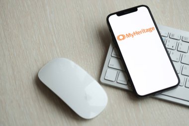 KYIV, UKRAINE - 17 Mart 2024 MyHeritage logosu iPhone ekranında elma klavyesi ve fareyle birlikte. Yapay Zeka Motoru