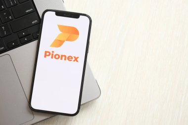 KYIV, UKRAINE - 15 Mart 2024 Pionex logosu MacBook panelinde iPhone ekranında. Kripto döviz portalı