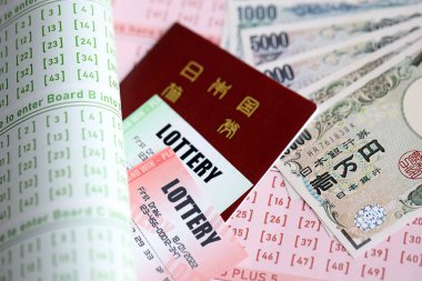 Piyango biletleri, Japon yen banknotlarıyla kumar kağıtlarının üzerinde piyango oynamak için işaretlenmiş numaralarla yatar. Piyango konsepti ya da kumar bağımlılığı