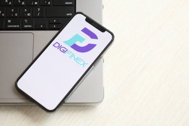 KYIV, UKRAINE - 15 Mart 2024 Digifinex logosu iPhone ekranında MacBook panelinde. Kripto döviz portalı