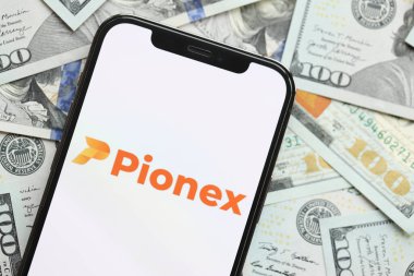 KYIV, UKRAINE - 15 Mart 2024 Pionex logosu iPhone ekranında yüzlerce dolarlık banknotlarla. Kripto döviz portalı