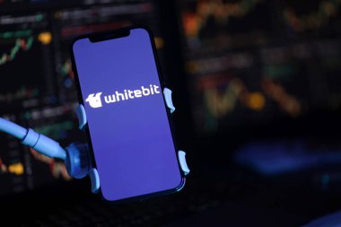KYIV, UKRAINE - iPhone ekranında 15 Mart 2024 Whitebit logosu ve kripto para birimi değer grafikleri. Kripto döviz portalı