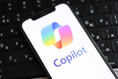 KYIV, UKRAINE - 17 Mart 2024 Microsoft Copilot logosu iPhone ekranda ve MacBook klavyesinde. Yapay Zeka Motoru