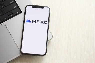 KYIV, UKRAINE - 15 Mart 2024 MacBook panelinde iPhone ekranında logo. Kripto döviz portalı