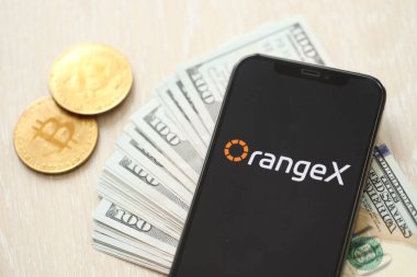 KYIV, UKRAINE - 15 Mart 2024 OrangeX logosu iPhone ekranında dolar ve bitcoin ile. Kripto döviz portalı