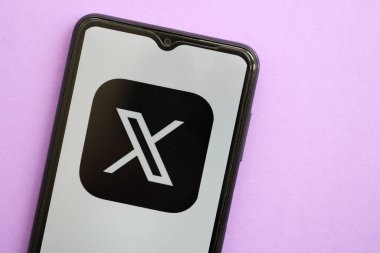 KYIV, UKRAINE - 1 Nisan 2024 Twitter X simgesi mor masadaki akıllı telefon ekranında. Leylak arka planında uygulama logosu olan iPhone görüntüsü