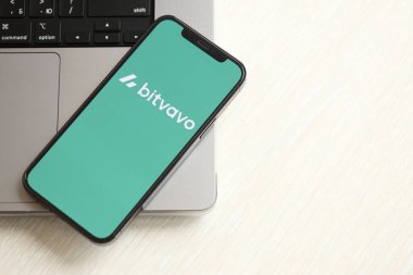 KYIV, UKRAINE - 15 Mart 2024 Bitvavo logosu MacBook panelinde iPhone ekranında. iPhone ekranında şifreli döviz portalı logosu ve MacBook 'ta dolar ve bitcoin var. Kripto para birimi