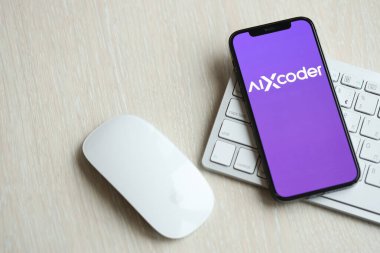 KYIV, UKRAINE - 17 Mart 2024 AIXcoder logosu iPhone ekranında elma klavyesi ve fareyle birlikte. Yapay Zeka Motoru