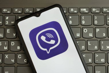 KYIV, UKRAINE - 1 Nisan 2024 Viber kurye simgesi siyah klavyede akıllı telefon ekranında. Koyu tuş takımı düğmelerinde uygulama logosu olan iPhone görüntüsü