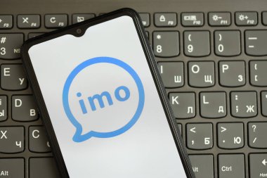 KYIV, UKRAINE - 1 Nisan 2024 İmo kurye simgesi siyah klavyede akıllı telefon ekranında. Koyu tuş takımı düğmelerinde uygulama logosu olan iPhone görüntüsü