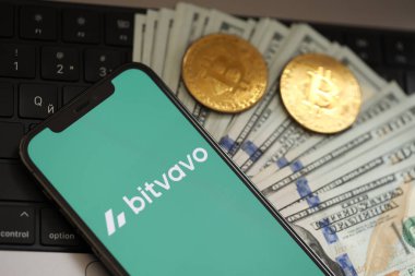 KYIV, UKRAINE - 15 Mart 2024 Bitvavo logosu iPhone ekranında dolar ve bitcoin ile MacBook. Kripto döviz portalı