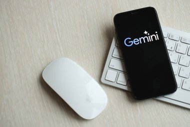 KYIV, UKRAINE - 17 Mart 2024 Gemini logosu iPhone ekranında elma klavyesi ve fareyle birlikte. Yapay Zeka Motoru