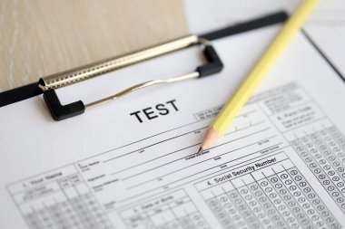 Öğrenciler için boş eğitim sınavı kalemi yakın bir şekilde sınıftaki masada yatıyor.