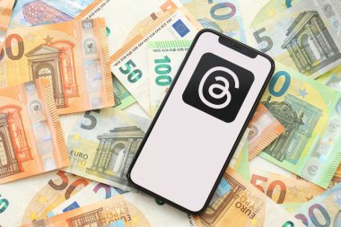 KYIV, UKRAINE - Nisan 1, 2024 Birçok euro banknotlarında akıllı telefon ekranındaki iplik simgesi. Avrupa para birimi euro banknotlu uygulama logosuyla iPhone görüntüsü