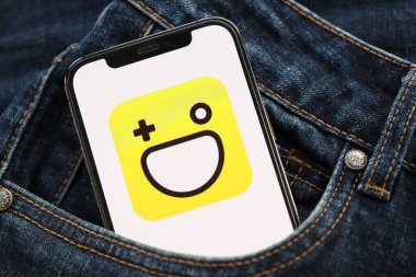 KYIV, UKRAINE - 1 Nisan 2024 Hago simgesi kot pantolon cebinde akıllı telefon ekranında. Uygulama logosuna sahip iPhone görüntüsü. Moda görünümlü kotların cebinde gizleniyor.
