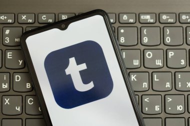 KYIV, UKRAINE - Nisan 1, 2024 Tumblr simgesi siyah klavyede akıllı telefon ekranında. Koyu tuş takımı düğmelerinde uygulama logosu olan iPhone görüntüsü