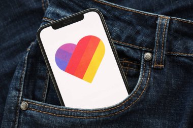 KYIV, UKRAINE - 1 Nisan 2024 Kotların cebindeki akıllı telefon ekranındaki simge gibi. Uygulama logosuna sahip iPhone görüntüsü. Moda görünümlü kotların cebinde gizleniyor.