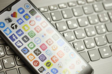 KYIV, UKRAINE - Nisan 1, 2024 Siyah klavyede birçok uygulama simgesi var. Koyu tuş takımı düğmelerinde uygulama logosu olan iPhone görüntüsü