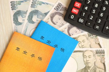 Japon emeklilik sigortası broşürleri yeni para faturaları ve hesap makineleri ile masaya yakın.