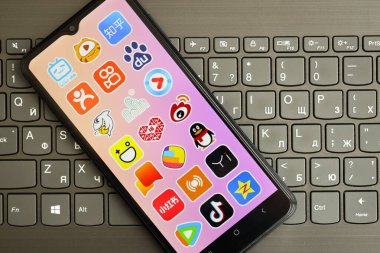 KYIV, UKRAINE - 1 Nisan 2024 Asya uygulama simgesi siyah klavyede akıllı telefon ekranında. Koyu tuş takımı düğmelerinde uygulama logosu olan iPhone görüntüsü
