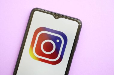 KYIV, UKRAINE - 1 Nisan 2024 Instagram simgesi mor masadaki akıllı telefon ekranında. Leylak arka planında uygulama logosu olan iPhone görüntüsü