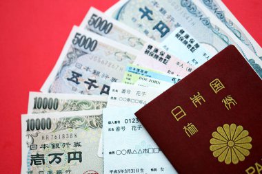 Açık mavi ve kırmızı Japon Sağlık Sigortası kartları Japon ikamet kartı ve telefon kartımla birlikte masada.