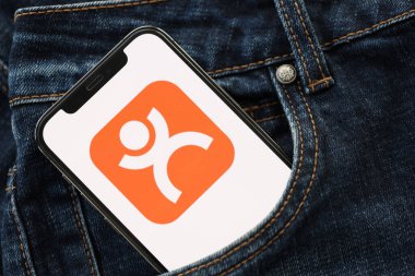 KYIV, UKRAINE - 1 Nisan 2024 Kotların cebindeki akıllı telefon ekranında Dianping platform simgesi. Uygulama logosuna sahip iPhone görüntüsü. Moda görünümlü kotların cebinde gizleniyor.