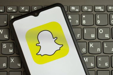 KYIV, UKRAINE - Nisan 1, 2024 Snapchat simgesi siyah klavyede akıllı telefon ekranında. Koyu tuş takımı düğmelerinde uygulama logosu olan iPhone görüntüsü