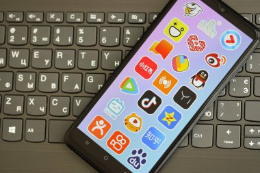 KYIV, UKRAINE - 1 Nisan 2024 Asya uygulama simgesi siyah klavyede akıllı telefon ekranında. Koyu tuş takımı düğmelerinde uygulama logosu olan iPhone görüntüsü