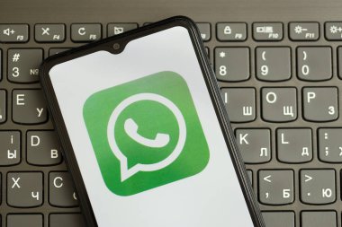 KYIV, UKRAINE - 1 Nisan 2024 Whatsapp kurye simgesi siyah klavyede akıllı telefon ekranında yakın plan. Koyu tuş takımı düğmelerinde uygulama logosu olan iPhone görüntüsü