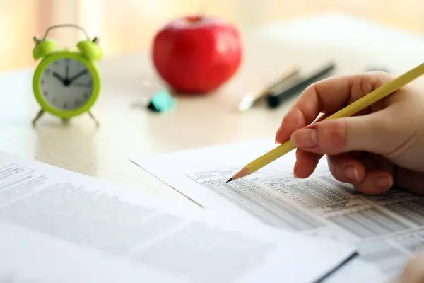 stock image Female student hands testing in exercise and taking fill in exam paper sheet with pencil at school test room, education concept