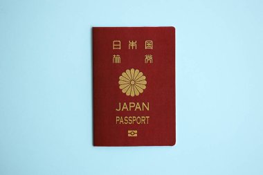 Japon pasaportu mavi arka planda, yakın plan. Turizm ve vatandaşlık kavramı