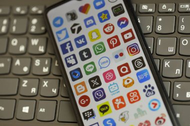 KYIV, UKRAINE - Nisan 1, 2024 Siyah klavyede birçok uygulama simgesi var. Koyu tuş takımı düğmelerinde uygulama logosu olan iPhone görüntüsü