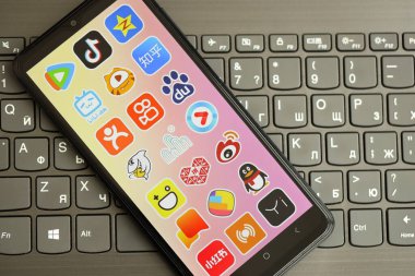 KYIV, UKRAINE - 1 Nisan 2024 Asya uygulama simgesi siyah klavyede akıllı telefon ekranında. Koyu tuş takımı düğmelerinde uygulama logosu olan iPhone görüntüsü