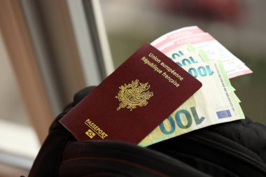 Fransız pasaportu ve Avro para faturaları ve sırt çantasındaki uçak biletleri.