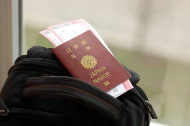 Japonya pasaportu ve turistik sırt çantasında uçak biletleri. Turizm ve seyahat kavramı