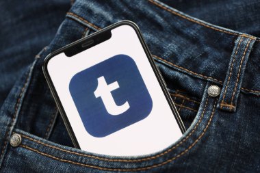 KYIV, UKRAINE - 1 Nisan 2024 Tumblr simgesi kot pantolon cebinde akıllı telefon ekranında. Uygulama logosuna sahip iPhone görüntüsü. Moda görünümlü kotların cebinde gizleniyor.