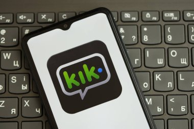 KYIV, UKRAINE - 1 Nisan 2024 Kik kurye simgesi siyah klavyede akıllı telefon ekranında kapalı. Koyu tuş takımı düğmelerinde uygulama logosu olan iPhone görüntüsü