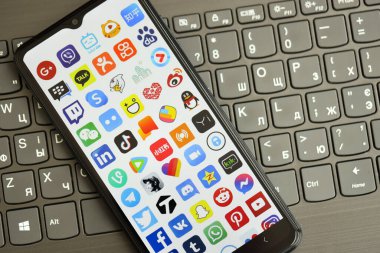 KYIV, UKRAINE - Nisan 1, 2024 Siyah klavyede birçok uygulama simgesi var. Koyu tuş takımı düğmelerinde uygulama logosu olan iPhone görüntüsü