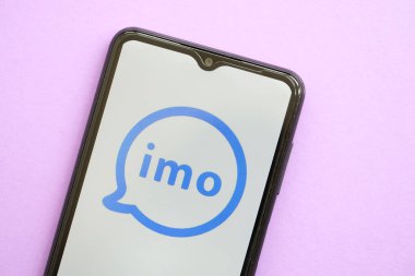 KYIV, UKRAINE - 1 Nisan 2024 İmo kurye simgesi mor masadaki akıllı telefon ekranında. Leylak arka planında uygulama logosu olan iPhone görüntüsü