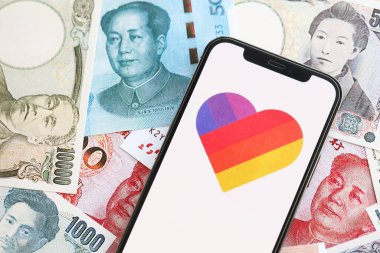 KYIV, UKRAINE - 1 Nisan 2024 Birçok Asya para bankasında akıllı telefon ekranındaki simge gibi. Japon yen ve Çin Yuan banknotları içeren uygulamalı iPhone ekranı