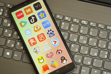 KYIV, UKRAINE - 1 Nisan 2024 Asya uygulama simgesi siyah klavyede akıllı telefon ekranında. Koyu tuş takımı düğmelerinde uygulama logosu olan iPhone görüntüsü