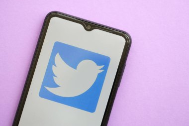 KYIV, UKRAINE - 1 Nisan 2024 Twitter simgesi mor masadaki akıllı telefon ekranında. Leylak arka planında uygulama logosu olan iPhone görüntüsü