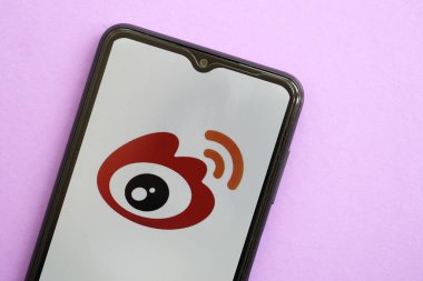 KYIV, UKRAINE - 1 Nisan 2024 Sina Weibo simgesi mor masadaki akıllı telefon ekranında. Leylak arka planında uygulama logosu olan iPhone görüntüsü