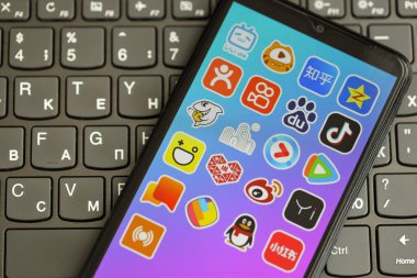 KYIV, UKRAINE - 1 Nisan 2024 Asya uygulama simgesi siyah klavyede akıllı telefon ekranında. Koyu tuş takımı düğmelerinde uygulama logosu olan iPhone görüntüsü