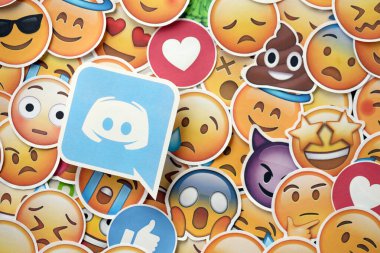 KYIV, UKRAINE - 20 Nisan 2024 Discord logosu ve Emoji sarı yüzlü büyük çıkartmalar. Emoji, elektronik mesajlarda ve web sayfalarında kullanılan ve metne gömülü bir resim veya gülen yüzdür.