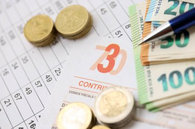 KYIV, UKRAINE - Modello 730 vergi formuyla birlikte 20 Nisan 2024 gelir bildirimi, vergi ödeme kavramı olarak İtalyancaya çevrilen banknotlar