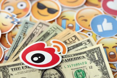 KYIV, UKRAINE - 20 Nisan, 2024 Weibo logosu ve birçok kullanım parası. Birçok emoji reaksiyonuna ilişkin ünlü sosyal ağ platformu ve dolar banknotlarının sembolü